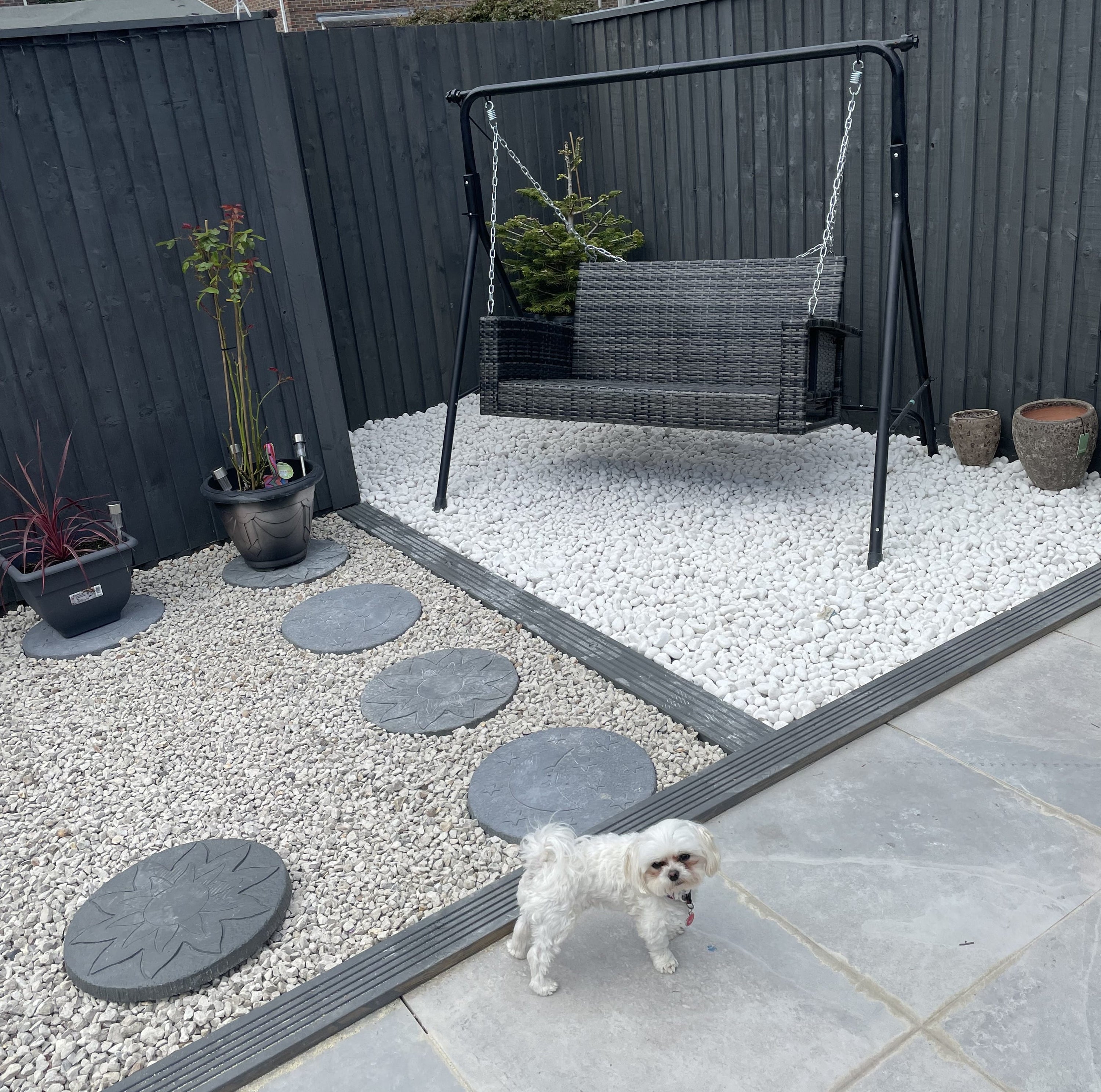 Garden patio with pebble borders and a swing seat