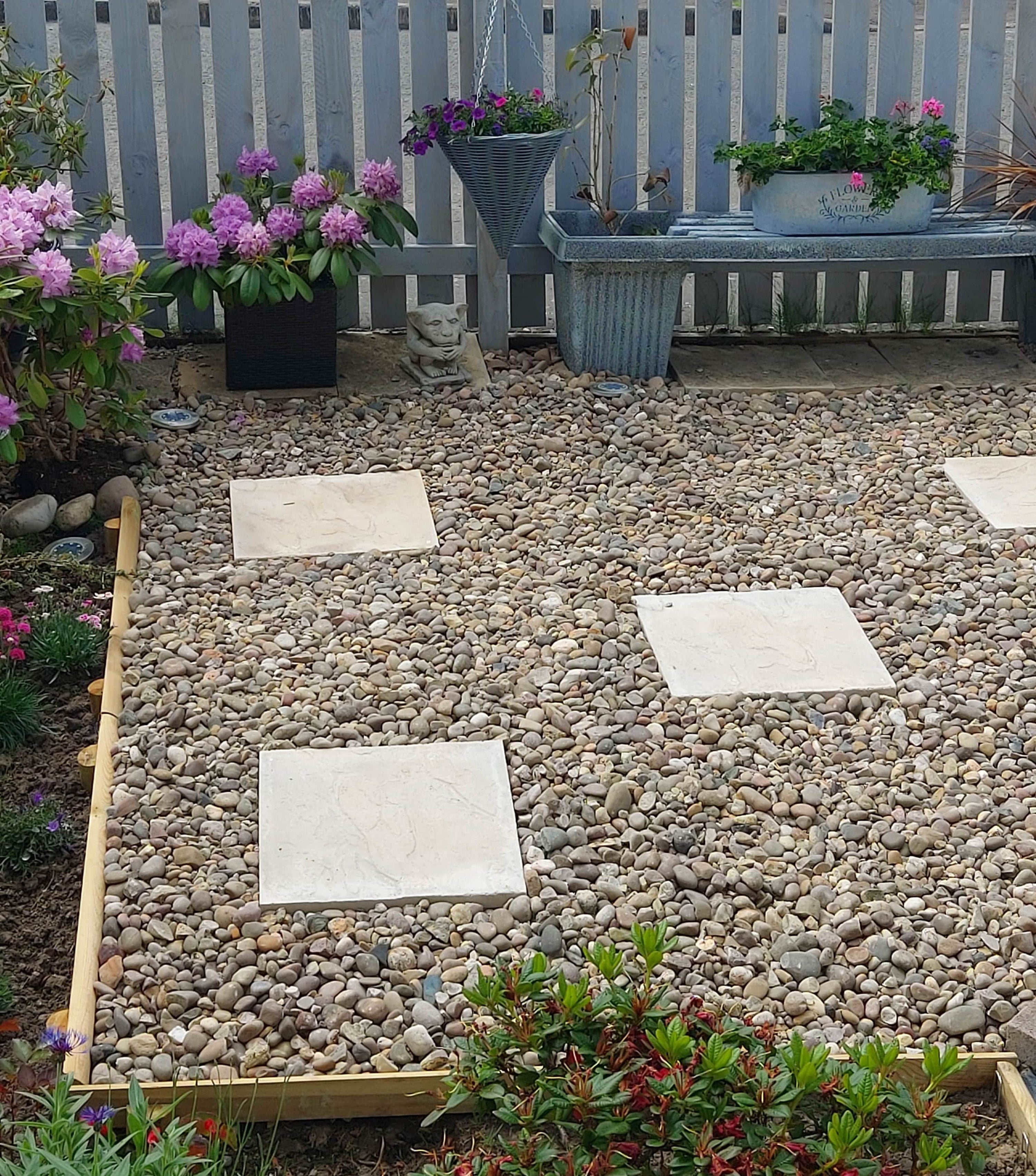 Large decorative aggregates used in a garden around a slab pathway