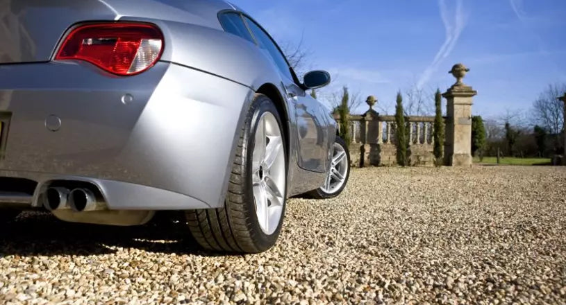 A car driving over a gravel driveway