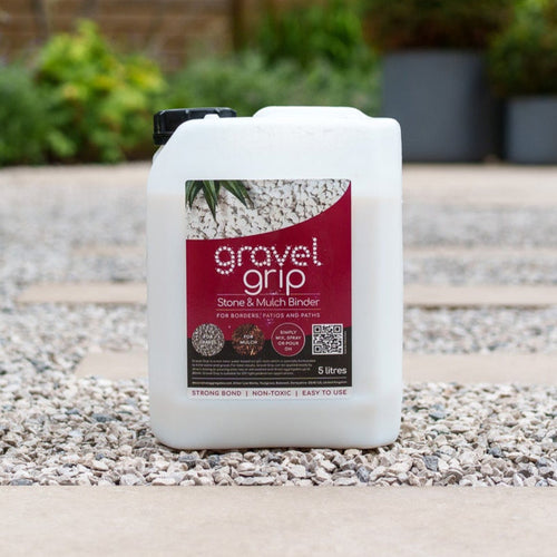Container of Gravel Grip on a gravel surface with plants in the background