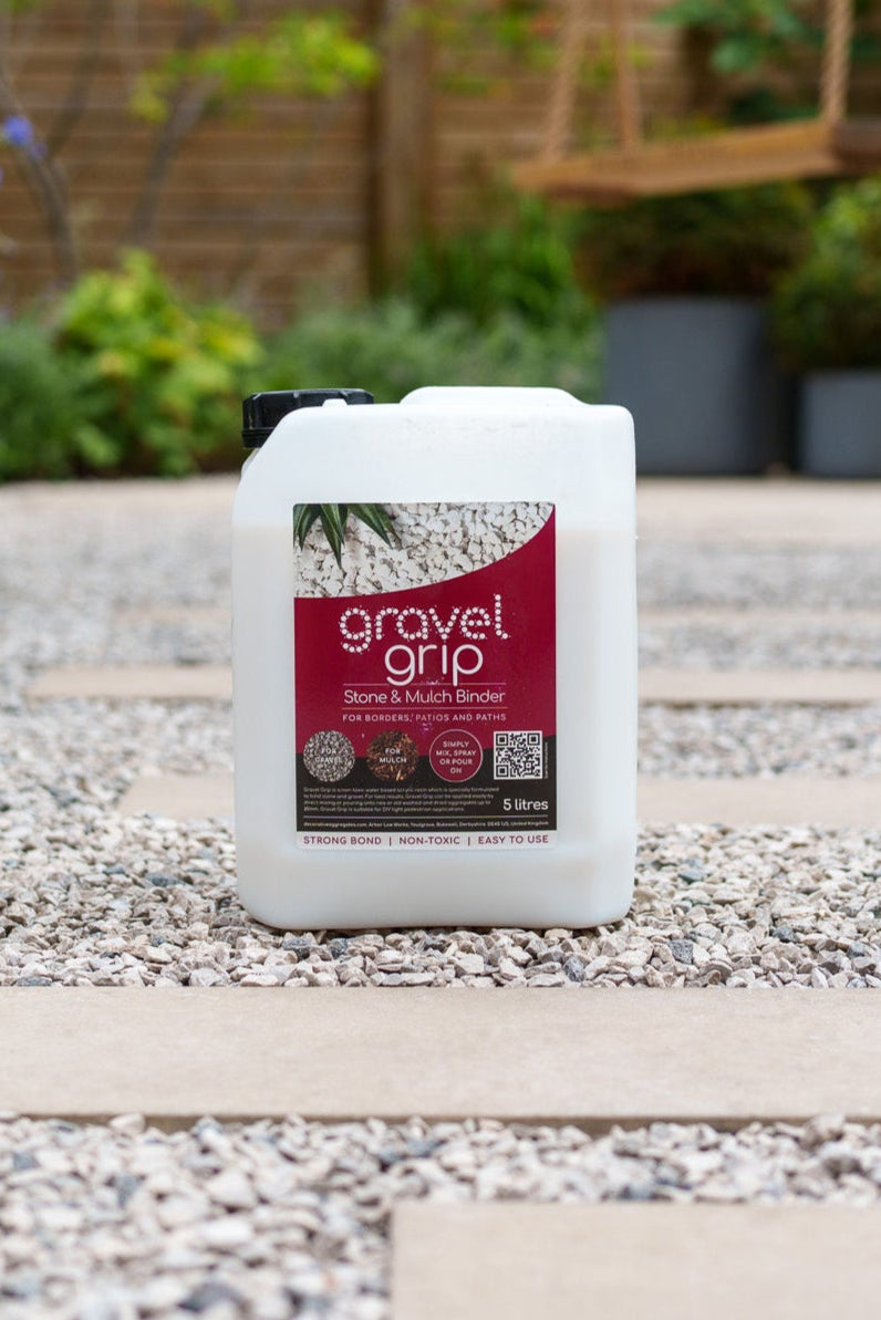 Container of Gravel Grip on a gravel surface with plants in the background
