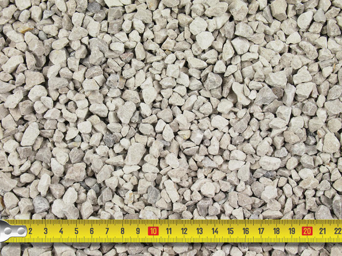 Image showcasing the size of grey limestone pebbledash 6mm aggregate with tape measure