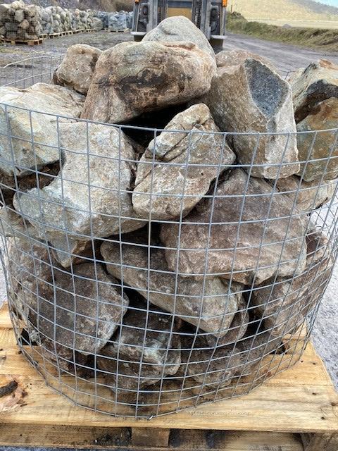 wire basket full of welsh quartz granite boulders