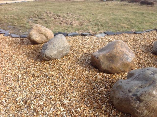 welsh quartz boulders laid on golden gravel near grass