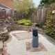 Cotswold Chippings Surrounding Water Feature In Garden