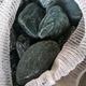 Close up photo of green cobble stones in a white net bag