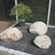 3 welsh quartz boulders 350-450mm laid in a rockery area with plantation 
