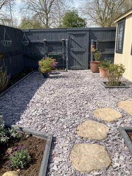 plum slate chippings used around traditional coloured paving slabs to enhance and complement each other in a back garden