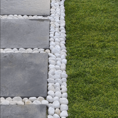white pebbles laid between grey paving slabs