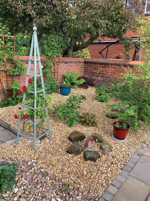 Area of garden dedicated to planting, laid with decorative gravel stones 