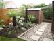 garden featuring planting area, trees and grey gravel ground covering 