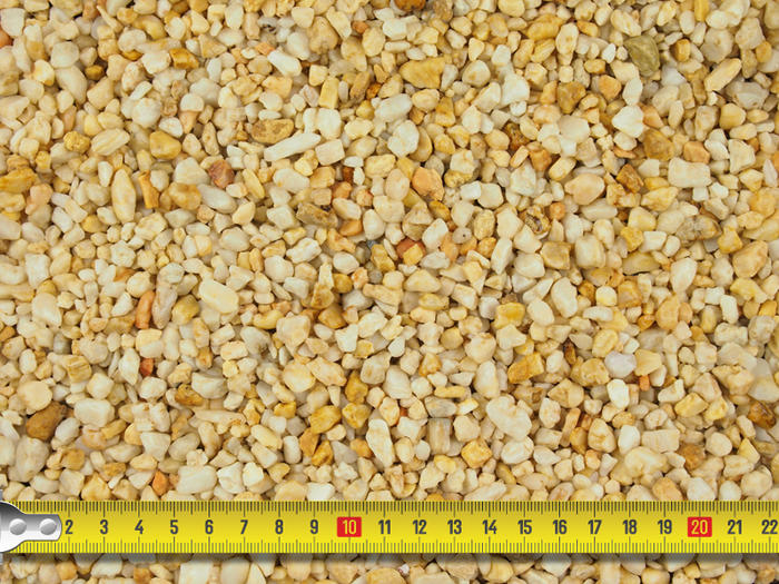 Barleycorn pebbledash with a tape measure to showcase size 